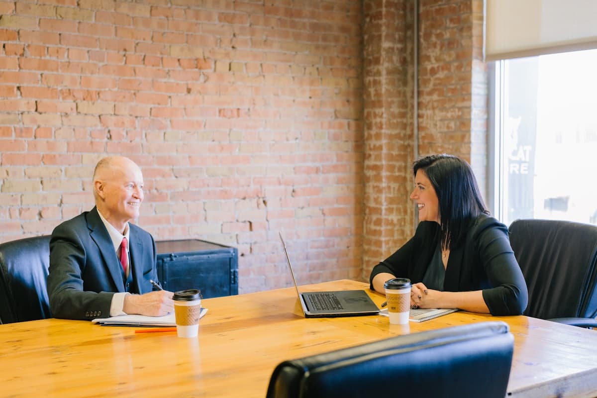 A consultation across a desk, documents out